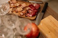 Close-up of sliced meats on a wooden tray with a knife, perfect for food blogs.